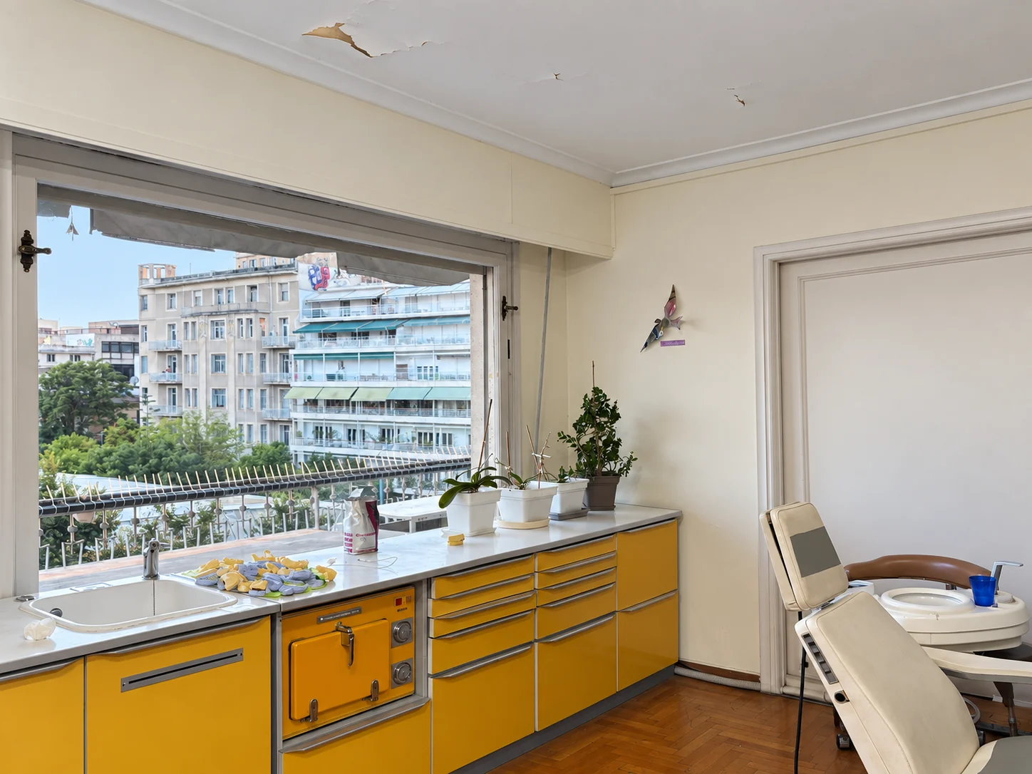 Treatment chair beside yellow cabinets and windows overlooking Athens